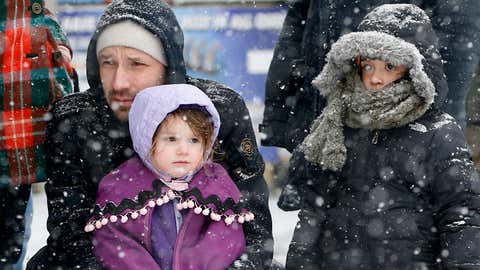 People snuggle up as they wait for marchers to pass during the all-inclusive St. Pat's For All parade in Sunnyside, Queens neighborhood of New York, Sunday, March 1, 2015. (AP Photo/Kathy Willens)