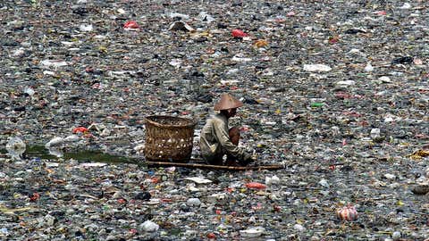 A man scavenges through a polluted river in Jakarta. (BAY ISMOYO/AFP/Getty Images)