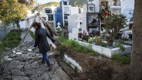 A woman walks over rubble next to a cemetery after an earthquake in Illapel, north of Santiago, Chile, on Sept. 17, 2015. (AFP/Getty Images)