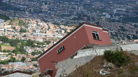 Collapsed houses in Ciudad del Angel, north from Tegucigalpa, on August 11, 2015. Built on geologically unstable hillsides, Ciudad del Angel has been declared unsuitable for occupation and will be demolished soon. So far 120 out of 250 houses built have already collapsed. (Orlando Sierra/AFP/Getty Images)