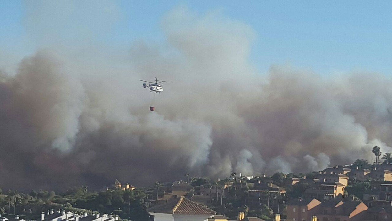 A helicopter carries water to dump on a fire in the province of Cadiz, Spain, on Tuesday, June 12, 2016. (Facebook/Larissa Miranda)