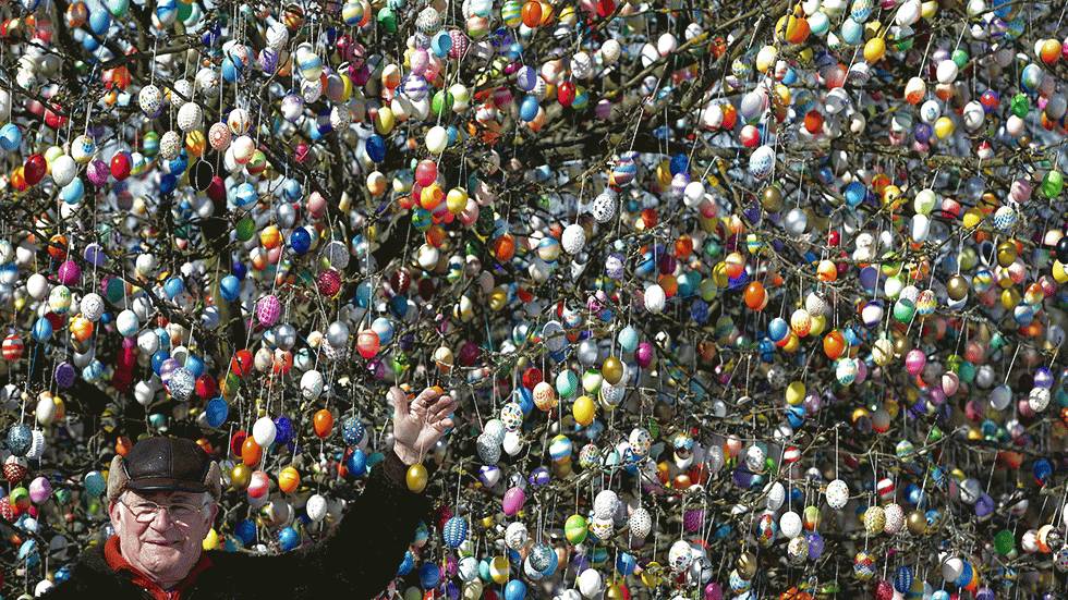 Volker Kraft stands in front of his apple tree, which he and his family have decorated with 10,000 Easter eggs on March 24, 2013, in Saalfeld, Germany. (Thomas Lohnes/Getty Images)