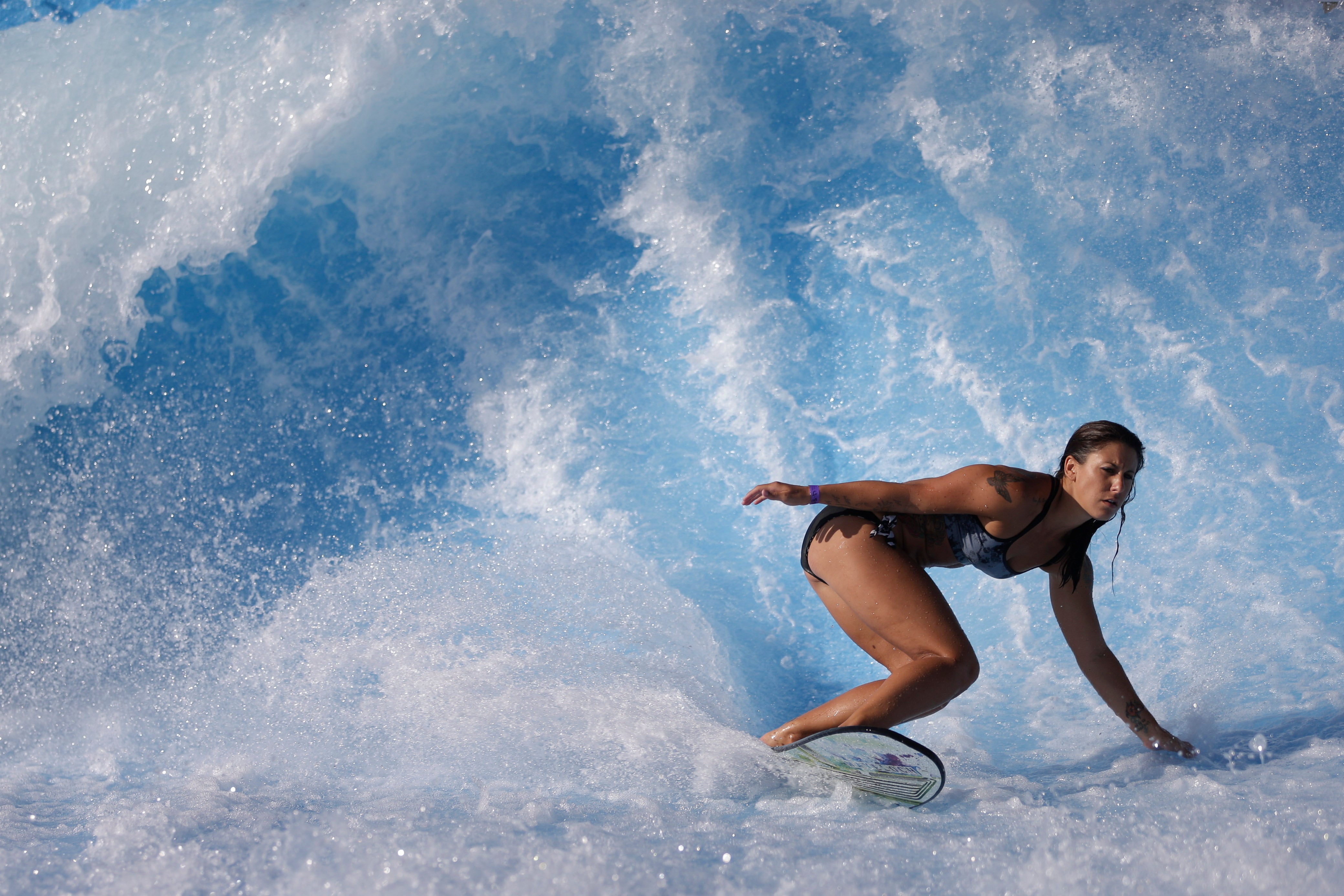 Sammantha Aker, of Huntington Beach, Calif., rides the machine-made wave at Wavehouse San Diego, Wednesday, Sept. 18, 2013, in San Diego. (AP Photo/Gregory Bull)