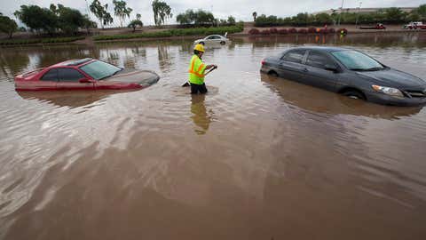 Arizona Department of Transportation (ADOT) worker Carlos Parra looks for drains to clear flood waters on I-10 east at 43rd Ave. after monsoon rains flooded the freeway in Phoenix, Monday, Sept. 8, 2014. (AP Photo/The Arizona Republic, Michael Chow)