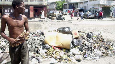 A man walks past rubbish on Aug. 19, 2005 in the commercial center of Port-au-Prince, Haiti. (Thony Belizaire/AFP/Getty Images)