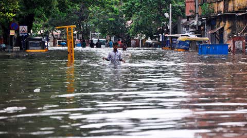 A boy wades through a flooded street in Chennai, in the southern Indian state of Tamil Nadu, Wednesday, Dec. 2, 2015. Weeks of torrential rains have forced the airport in the state capital Chennai to close and have cut off several roads and highways, leaving tens of thousands of people stranded in their homes, government officials said Wednesday. (AP Photo)