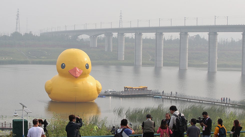 Reporters crowd the waterfront to see the 59-foot tall rubber duck at Beijing Garden Expo Park on September 6, 2013 in Beijing, China. (Photo by Feng Li/Getty Images)
