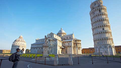 A tourist takes a photo at sunrise on May 8, 2011, of the leaning tower of Pisa in an empty square. (Fabio Muzzi/AFP/Getty Images)