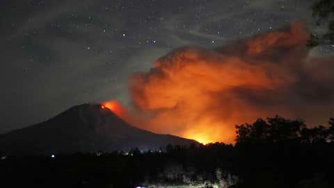 Mount Sinabung spews volcanic materials and hot molten lava from its crater as seen from Tiga Pancur, North Sumatra, Indonesia, early Thursday, June 25, 2015. (AP Photo/Binsar Bakkara)