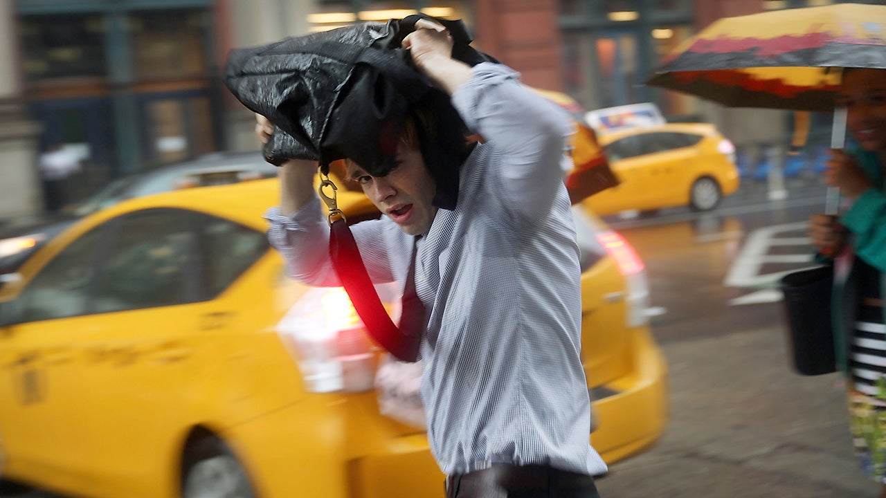 A man takes cover during an afternoon downpour and thunderstorm in Manhattan on July 15, 2014. (Spencer Platt/Getty Images)