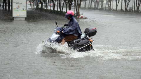 A motorcyclist rides through a flooded area in Jinjiang, south China's Fujian province of July 23, 2014 as typhoon Matmo makes landfall in China. (AFP/Getty Images)