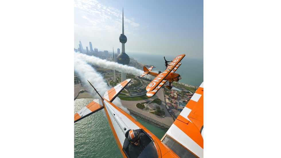 Breitling Wingwalker Freya Paterson flies above Kuwait City's iconic Water Towers with pilots David Barrell and Martyn Carrington on Thursday, March  6, 2014.  The team loop and roll up to 160 mph enduring G-forces of 4-5g. (Katsuhiko Tokunaga/Breitling via AP Images)