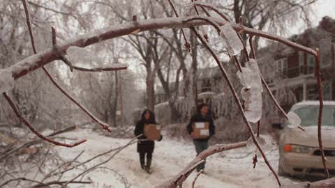 Residents of Montreal, Canada walk with their belongings to their cars while seeking shelter after losing Jan. 8, 1998. Credit: MARCOS TOWNSEND/AFP/Getty Images