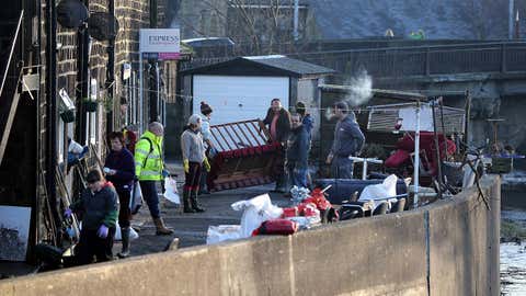 Residents outside their houses after yesterday's floods on Dec. 27, 2015 in Mythelmroyd, England. (Nigel Roddis/Getty Images)