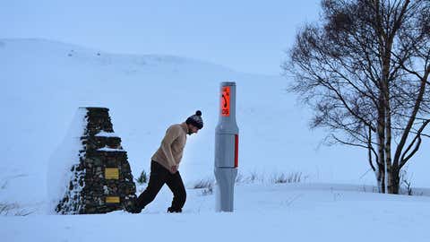 A tourist stops to look at the winter landscape as snow continues to fall on January 14, 2015 in Tyndrum, Scotland. (Mark Runnacles/Getty Images)