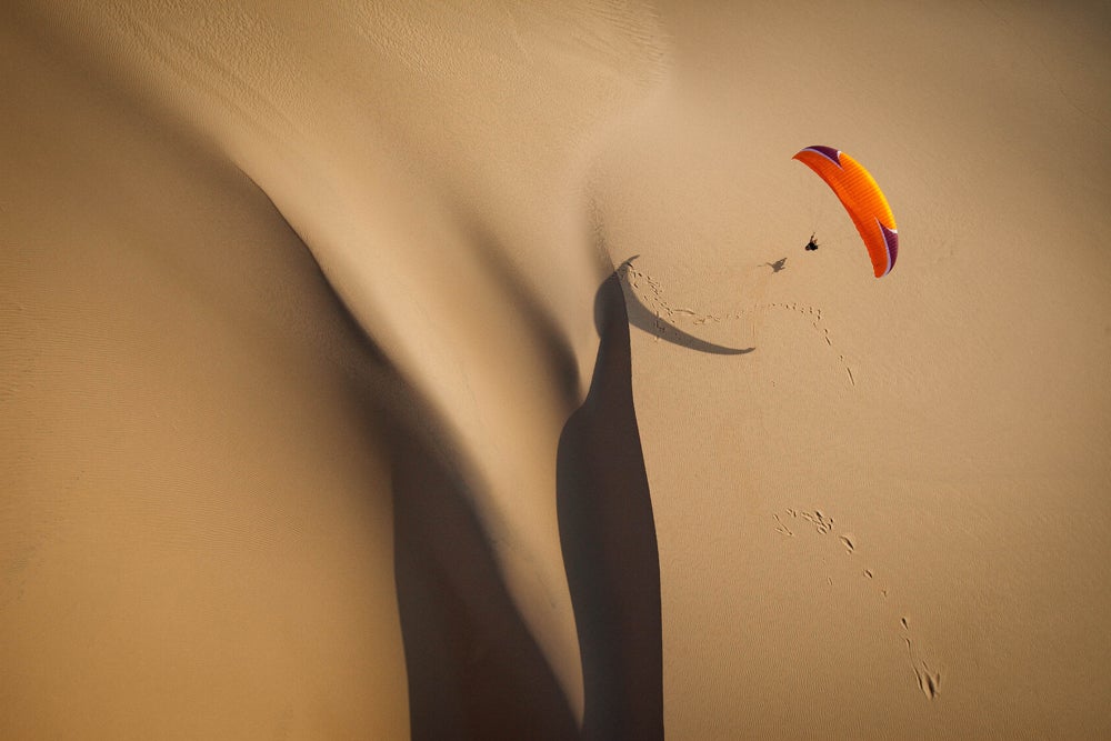 Another gorgeous shot of a paraglider flying over the large sand dune in the Bazaruto Archipelago in Africa. (Image: Jody MacDonald)