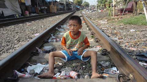 A young boy plays amongst the rubbish along a railway line on July 3, 2004, in a slum area of Jakarta, Indonesia. (Choo Youn-Kong/AFP/Getty Images)