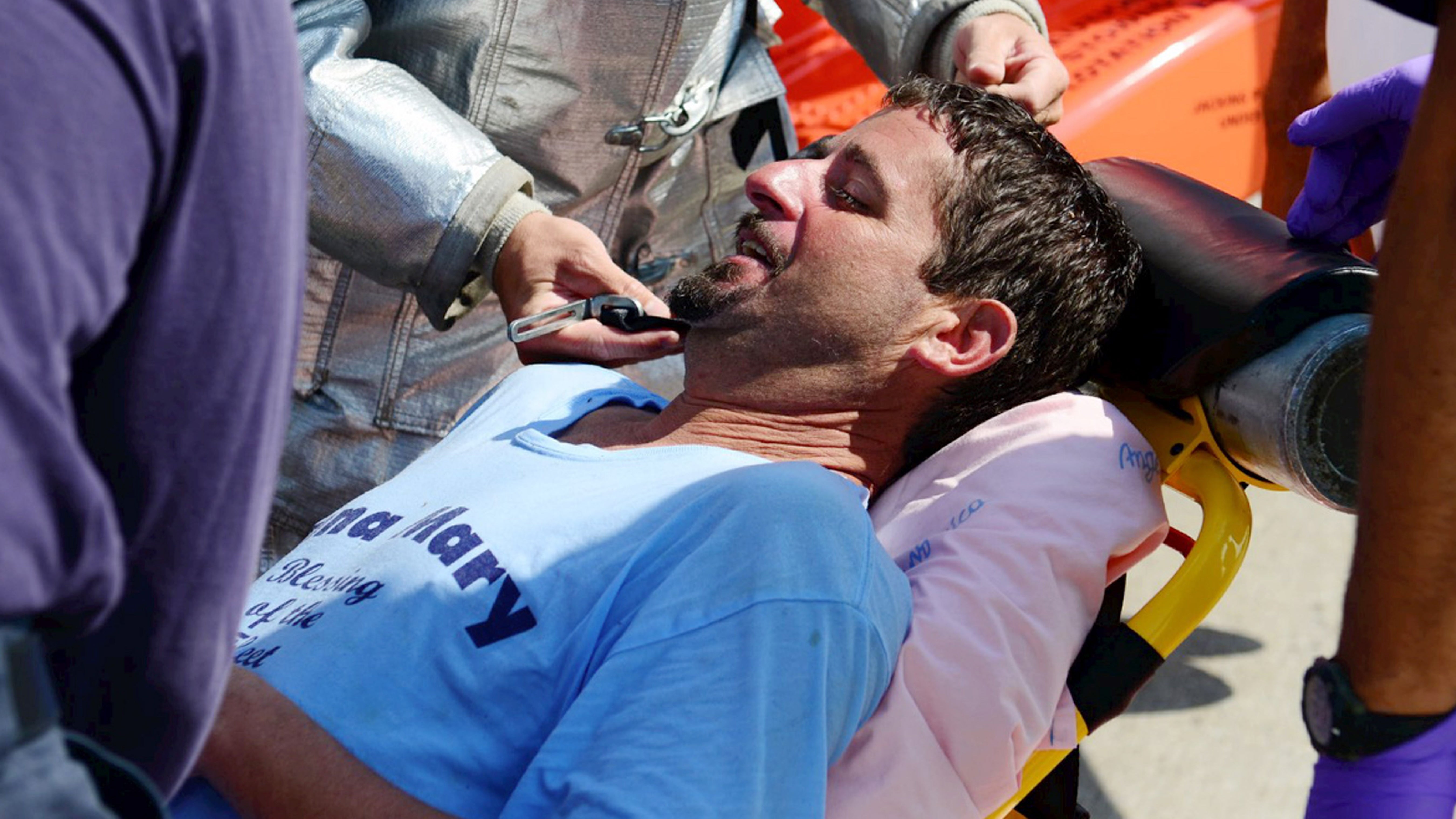 In this photo of Wednesday, July 24, 2013, provided by the US Coast Guard, lobsterman John Aldridge lies on a stretcher at Air Station Cape Cod in Sandwich, Mass. after being rescued by a Coast Guard helicopter. (AP Photo/US Coast Guard, Ross Ruddell)