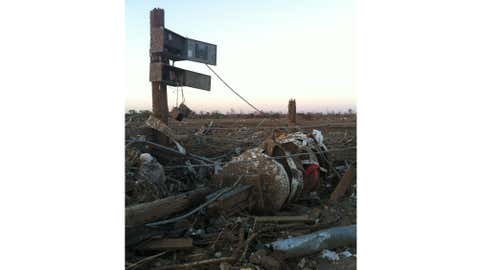 A damaged tornado siren near the demolished Plaza Towers Elementary School in Moore, Okla., the day after a catastrophic EF5 twister struck the town. Here, the electronic system and batteries are visibly dangling from the siren's power box. (Gayland Kitch/City of Moore)