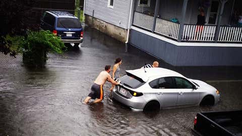 Residents attempt to move a car out of a flooded street in Fairhaven, MA (Photo: Twitter/thatshawesome)