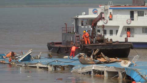 In this photo released by China's Xinhua News Agency, rescuers work on the top of the capsized Eastern Star after being righted by cranes on the Yangtze River in Jianli county of southern China’s Hubei province Friday, June 5, 2015. (Xiao Yijiu/Xinhua via AP)