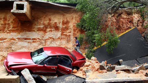 People survey the damage on Scenic Highway after part of the highway collapsed following heavy rains and flash flooding on April 30, 2014 in Pensacola, Florida. (Marianna Massey/Getty Images)