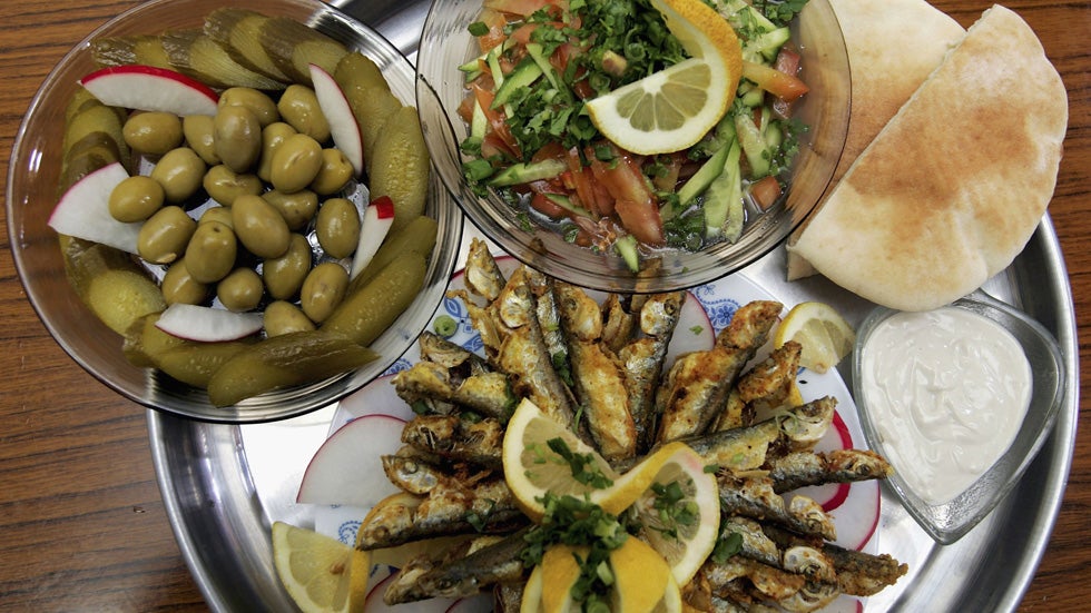 A meal of fried sardines with tehina sauce, fresh pita, a cucumber and tomato salad, olives and pickles is served in a restaurant in the local produce market Feb. 22, 2006 in Netanya in central Israel. (David Silverman/Getty Images)