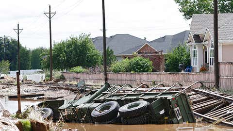 An M-923 U.S. military logistical transportation vehicle lies on its side in a ditch in Longmont after being washed away by floodwaters as local residents were cleaning up in the wake of heavy flooding on Sept. 16, 2013, in Longmont, Colo. (Marc Piscotty/Getty Images)