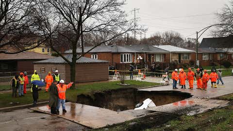 Workers prepare to pull vehicles from a sinkhole that opened up on a residential street in the South Deering neighborhood on April 18, 2013 in Chicago, Ill. (Scott Olson/Getty Images)