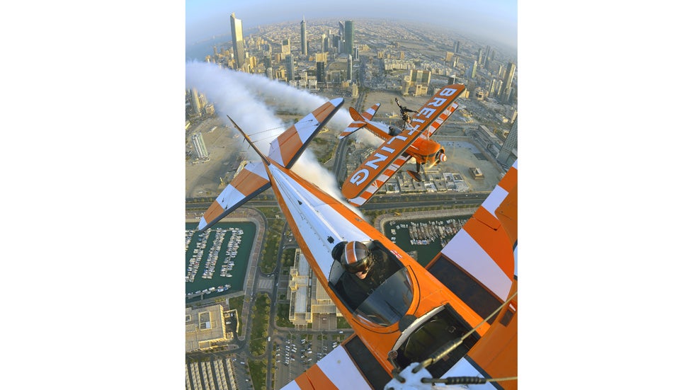 Breitling Wingwalker Freya Paterson flies above Kuwait City's iconic Water Towers with pilots David Barrell and Martyn Carrington on Thursday, March  6, 2014.  The team loop and roll up to 160 mph enduring G-forces of 4-5g. (Katsuhiko Tokunaga/Breitling via AP Images)