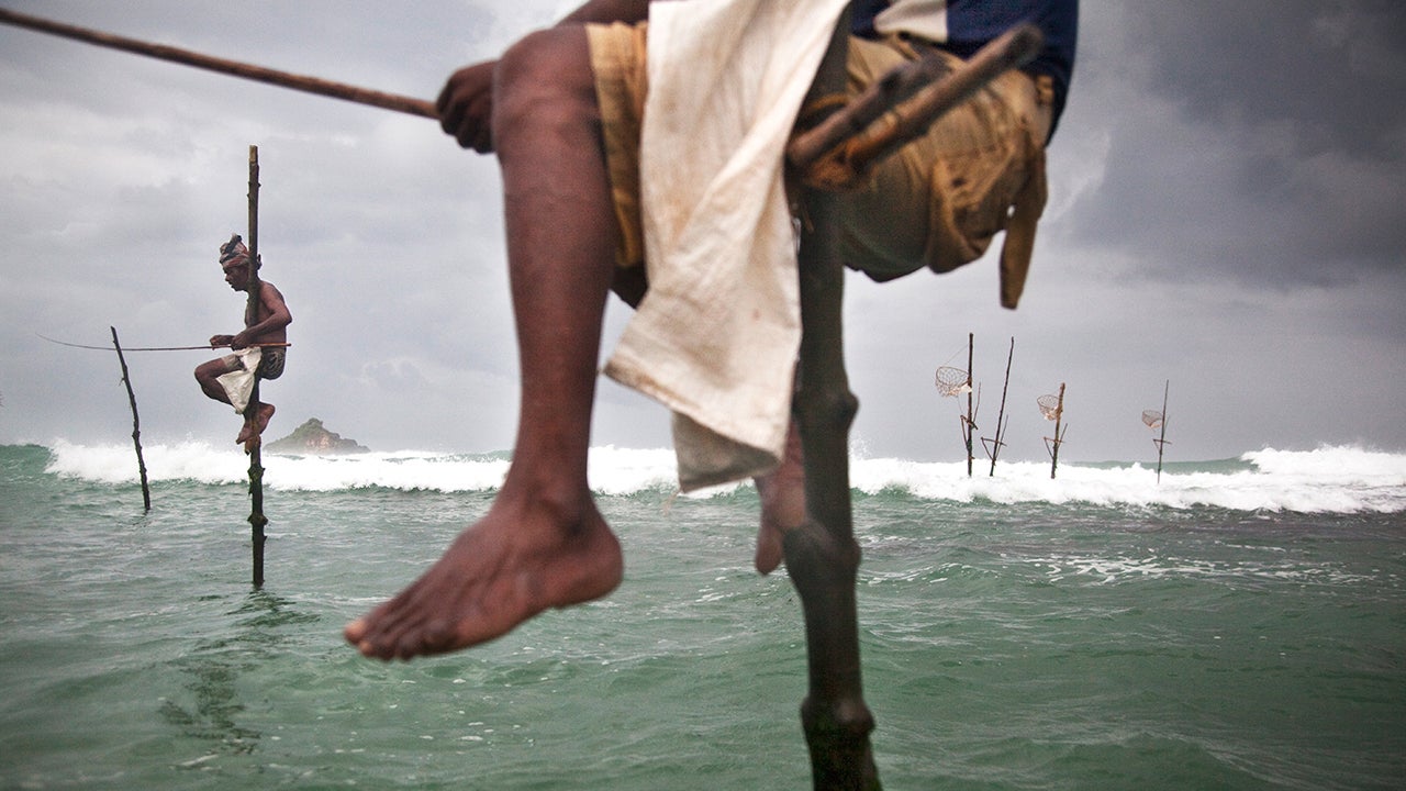 At dawn, stilt fishermen Nishanti Sunil and Anil Madushanka sit on their stilts and wait for fish. More and more often they sit in vain as the Bay of Ahangama off the coast of Sri Lanka is increasingly fished empty. (Florian M&uuml;ller)