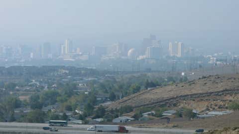 Traffic passes on U.S. Highway 395 northeast of downtown Reno on Monday, Sept. 22, 2014 as dense smoke drifts in from a California wildfire more than 60 miles away. (AP Photo/Scott Sonner)