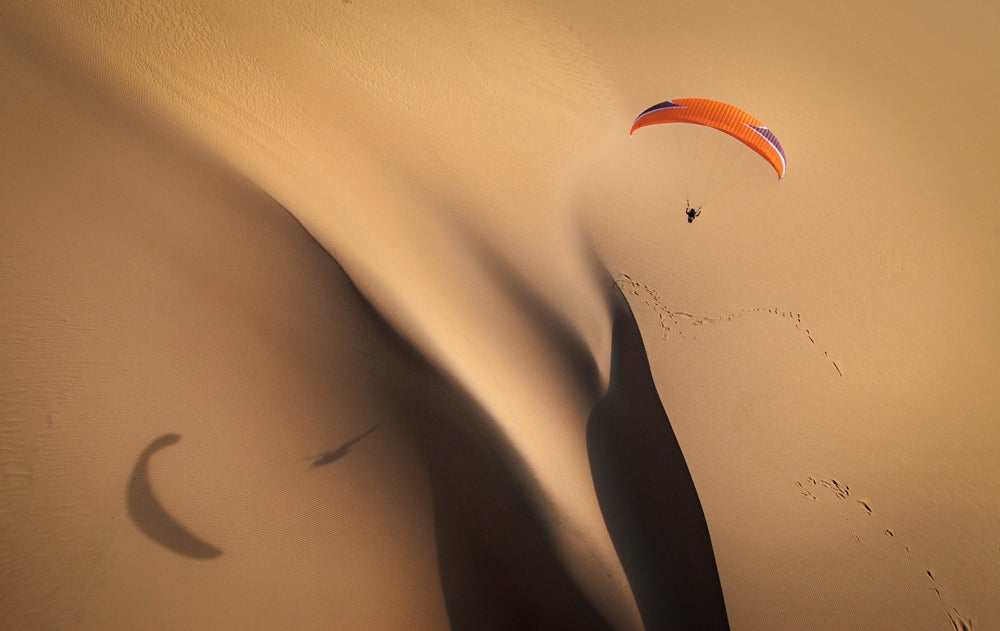 Ideal lighting and sun angles create a reflection of a paraglider on the sand dune. (Image: Jody MacDonald)