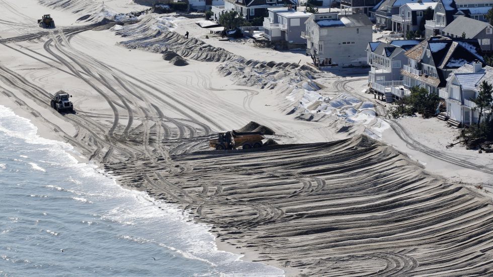 In this aerial photograph, heavy equipment pushes sand to restore a barrier dune along the Atlantic Ocean on Long Beach Island, N.J., Friday, Nov. 9, 2012, after the region was pounded by Superstorm Sandy the previous week.