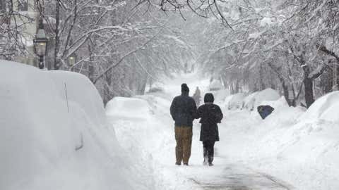 A man and woman stroll down a snow covered street in the Beacon Hill neighborhood of Boston, Saturday, Feb. 9, 2013. The Boston area received about two feet of snow from a winter storm. A howling storm across the Northeast left the New York-to-Boston corridor shrouded in 1 to 3 feet of snow Saturday, stranding motorists on highways overnight and piling up drifts so high that some homeowners couldn't get their doors open. More than 650,000 homes and businesses were left without electricity. (AP Photo/Charles Krupa)