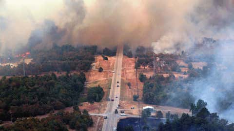 Highway 48 is covered in smoke as flames continue, Saturday, Aug 4, 2012, east of Drumright, Okla.