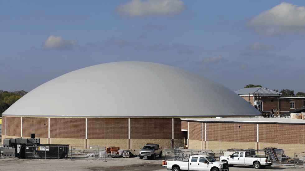 Work continues on the construction of a new domed gym at Edna High School in Edna, Texas. The hurricane dome, a structure being built in part with money from the Federal Emergency Management Agency, can be used to house first responders or residents evacuated during a storm. (AP Photo/David J. Phillip)