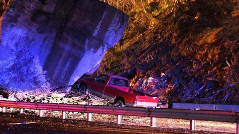 A massive boulder rests on the road near a truck in Lawrence County, Ohio, on the morning of Friday, April 10, 2015. (Melanie Chapman/WSAZ-TV)