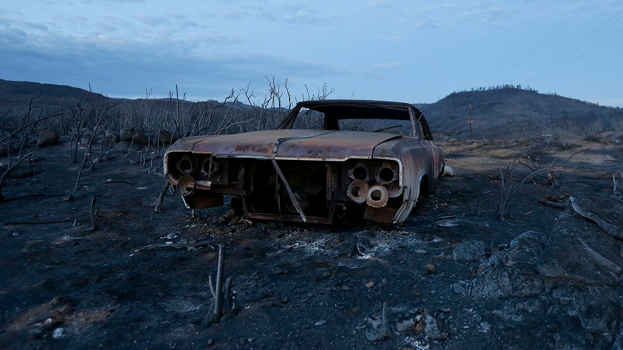 A car burned in the Rocky Fire is shown near Lower Lake, Calif., Tuesday, Aug. 4, 2015.  Firefighters made some progress Tuesday afternoon with some help from light rain that fell in the area. (AP Photo/Jeff Chiu)