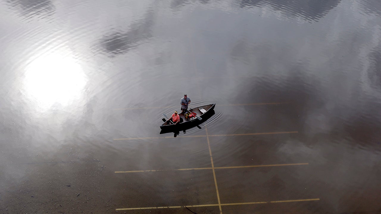 In this aerial photo, people prepare to launch a canoe from a flooded parking lot near Bear Creek Park Saturday, May 30, 2015, in Houston. The Colorado River in Wharton and the Brazos and San Jacinto rivers near Houston are the main focus of concern as floodwaters moved from North and Central Texas downstream toward the Gulf of Mexico. (AP Photo/David J. Phillip)