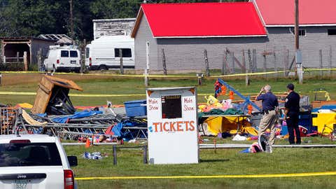 Investigators inspect the site of a circus tent that collapsed during a show by the Walker Brothers International Circus at the Lancaster Fairgrounds in Lancaster, New Hampshire, Tuesday Aug. 4, 2015. A quick moving storm with 60 mph winds hit the tent Monday shortly after the show started, killing a father and daughter. (AP Photo/Jim Cole)