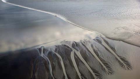 A group of surfers ride the Bore Tide at Turnagain Arm in Anchorage, Alaska, July 15, 2014. The Alaska Bore Tide has waves that can reach 6-10 feet tall and is the only one that occurs in the far north and the only one bordered by mountains. (Streeter Lecka/Getty Images)