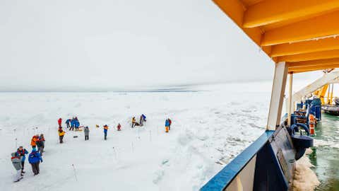 People gather on the ice next the Russian ship MV Akademik Shokalskiy that is trapped in thick Antarctic ice 1,500 nautical miles south of Hobart, Australia. (AP Photo/Australasian Antarctic Expedition/Footloose Fotography, Andrew Peacock)