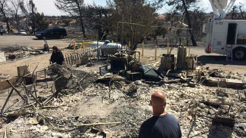 Summit Inn general manager Michelle Keeney, left, and Scott Keeney survey the destruction of their burned home in Oak Hills, Calif., on Friday, Aug. 19, 2016. The Summit Inn, a popular roadside diner at the crest of historic Route 66, was gutted by the Blue Cut wildfire on Tuesday, in the Cajon Pass which was right next door to their home. The Southern California fire unleashed its initial fury on a semi-rural landscape dotted with small ranches and homes in Cajon Pass and on the edge of the Mojave Desert before climbing the mountains.