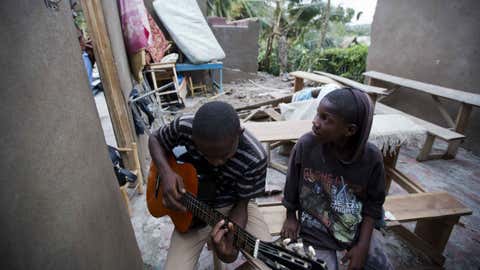 Two boys sit inside what is left of his home after it was damaged by Hurricane Matthew in Saint Louis, Haiti on Oct. 5, 2016. (AP Photo/Dieu Nalio Chery)