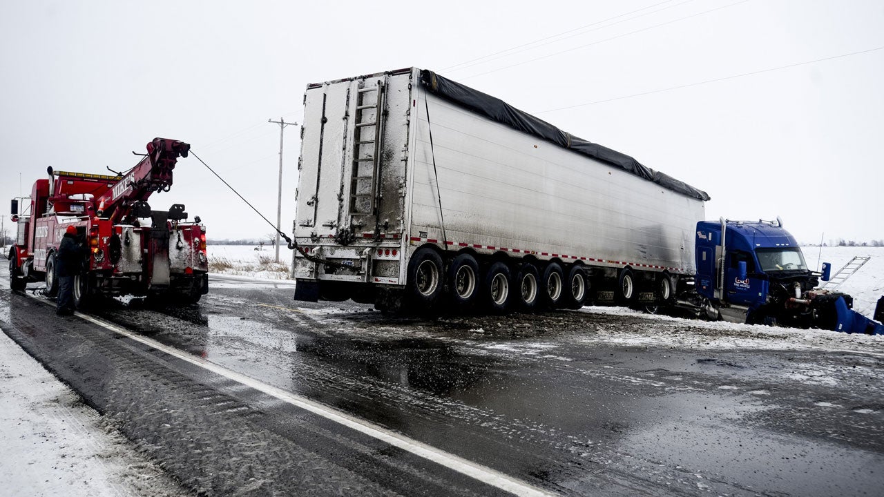Hampton Township and Frankenlust Township firefighters help remove a jackknifed semi tractor-trailer at Nolet Road in Hampton Township, Michigan, on Jan. 10, 2017. (Jacob Hamilton/The Bay City Times via AP)