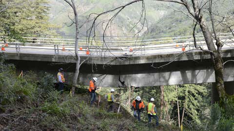 In this Wednesday, Feb. 22, 2017 photo, Caltrans engineers evaluate storm damage near a large crack where the Pfeiffer Canyon Bridge is sagging on Highway 1 in Big Sur, California. (David Royal /The Monterey County Herald via AP)