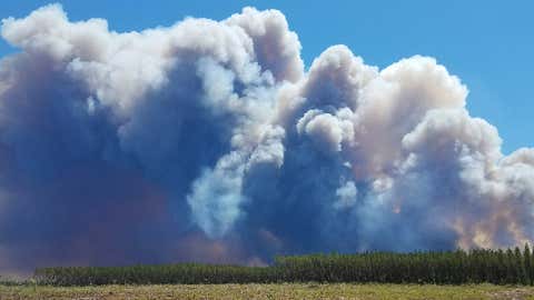 In this Saturday, May 6, 2017 photo provided by the Okefenokee National Wildlife Refuge, smoke rises from a wildfire east of Fargo, Georgia. (Ben Palm/Okefenokee National Wildlife Refuge via AP)