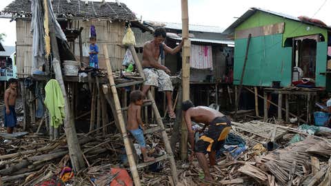 People repair a house destroyed by Typhoon Rammasun in Batangas, southwest of Manila on July 17, 2014, a day after the storm barreled over the region . (Ted Aljibe/Getty Images)