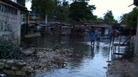 Residents wading through water in Belle Anse, Haiti, on Monday.